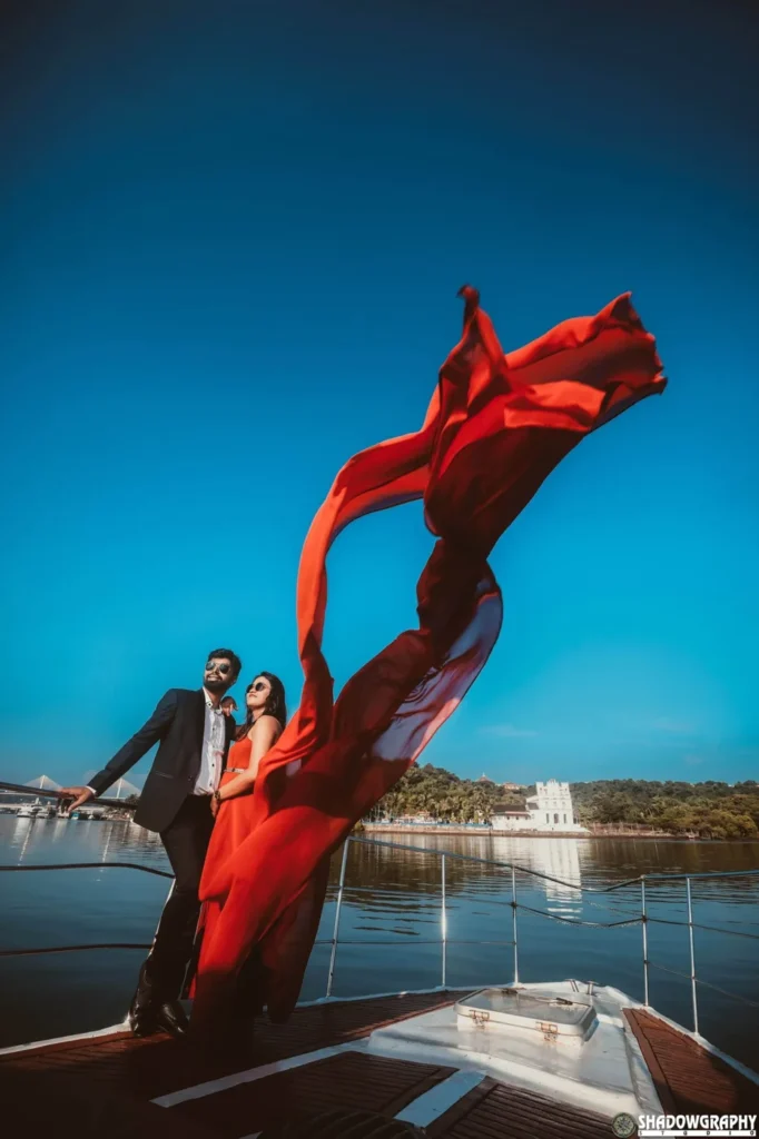 Couple with a flowing red dress beside a boat from Shadowgraphy Studio's pre-wedding portfolio